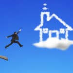 Businessman jumping from wooden board to house shape cloud